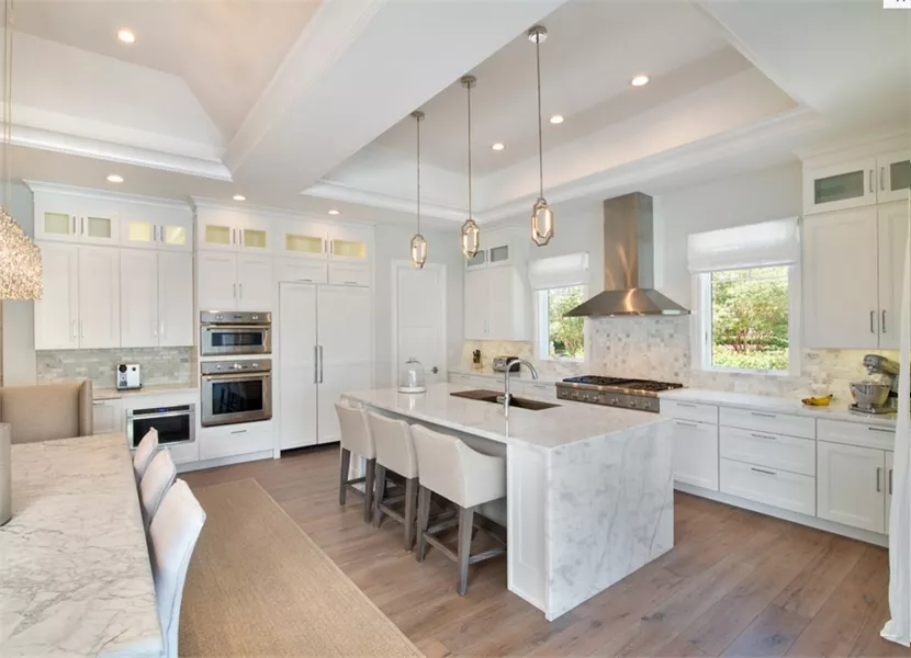Marble Island, Double Ovens, and Pendant Lights Define This White Kitchen