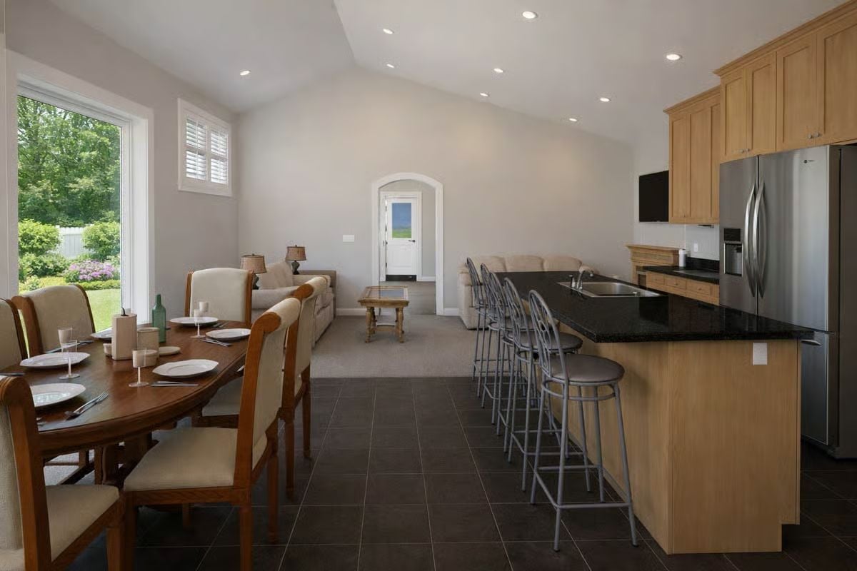 Kitchen Island with Dark Granite Top Anchors an Open-Plan Entertaining Space