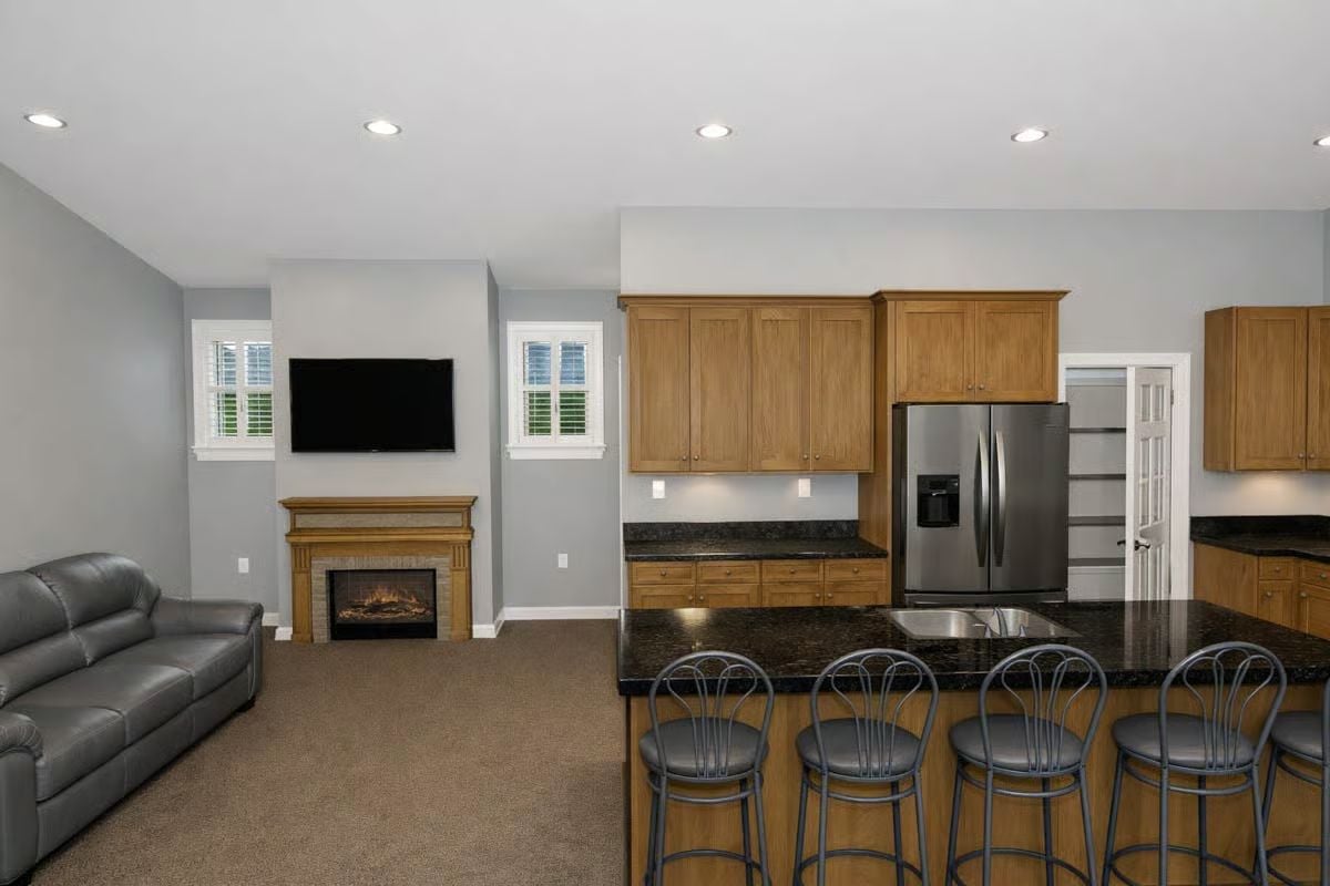 Warm Wood Cabinetry and Bar Seating Define This Kitchen-to-Living Room Connection
