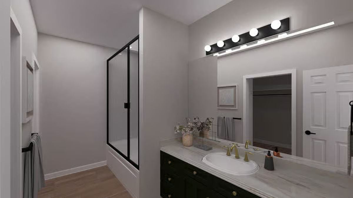 Gold Fixtures and Black Vanity Cabinet Bring Contrast to the Ensuite Bath
