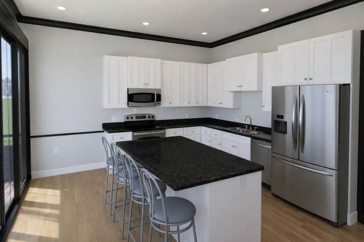 Dark Granite Island and Stainless Appliances Give This Kitchen a Sharp Contrast