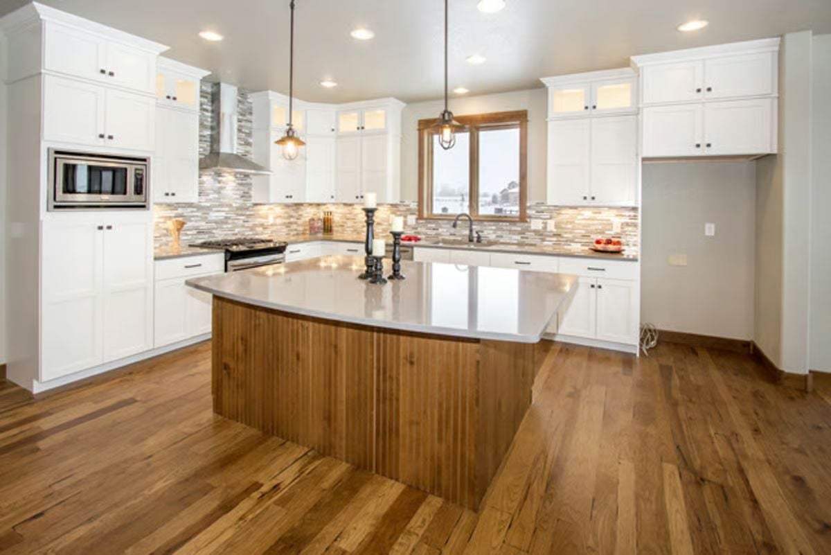 Curved Wood Island and Quartz Countertop Define a Craftsman Kitchen