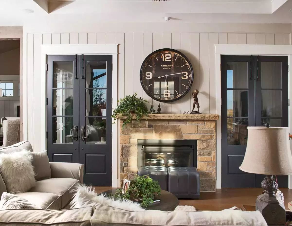 Shiplap Walls and Stone Fireplace Anchor a Farmhouse Living Room