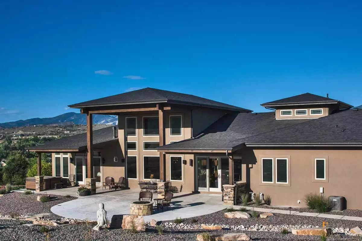 Craftsman Exterior Wraps a Covered Patio Around Mountain Views and a Stone Fire Pit