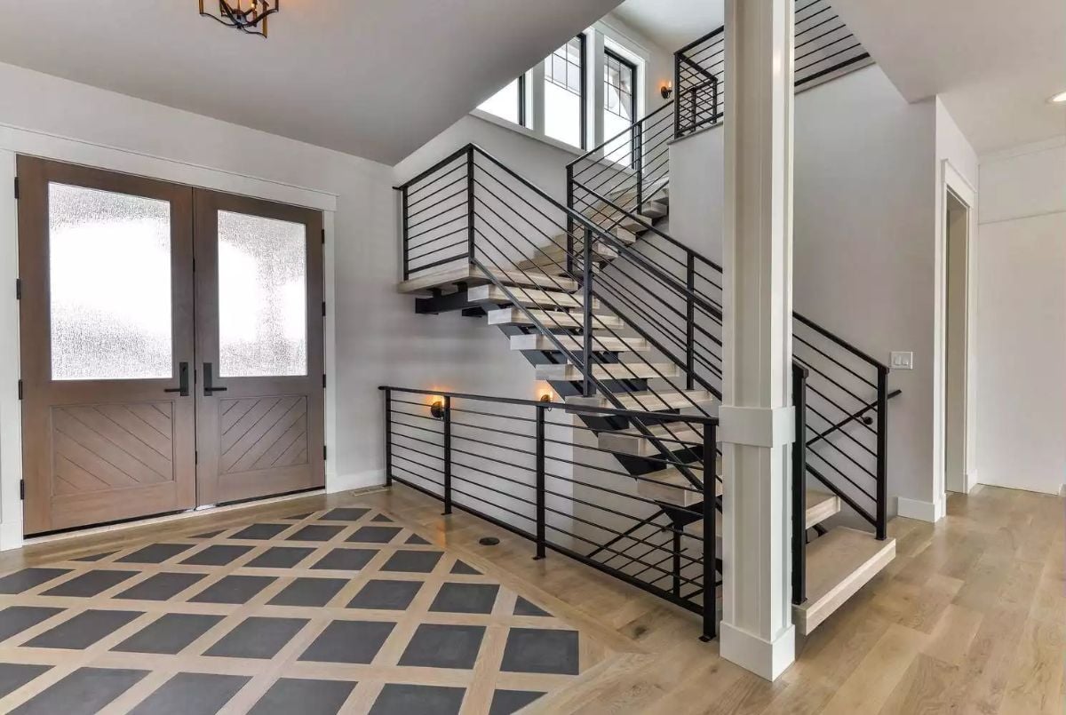 Floating Staircase Meets Industrial Railing in a Light-Filled Foyer