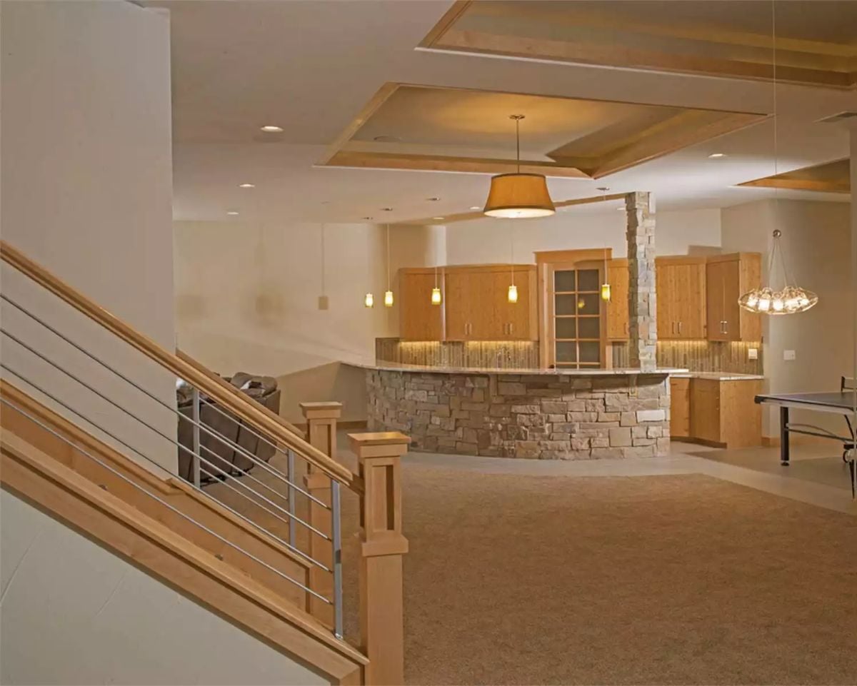 Curved Stone Bar Becomes the Focal Point of a Finished Basement Built for Entertaining