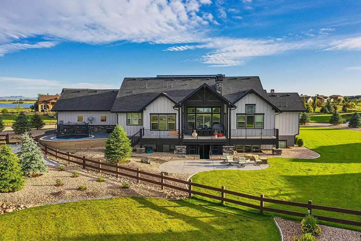 Wraparound Deck and Manicured Grounds Frame This Modern Farmhouse Rear Exterior