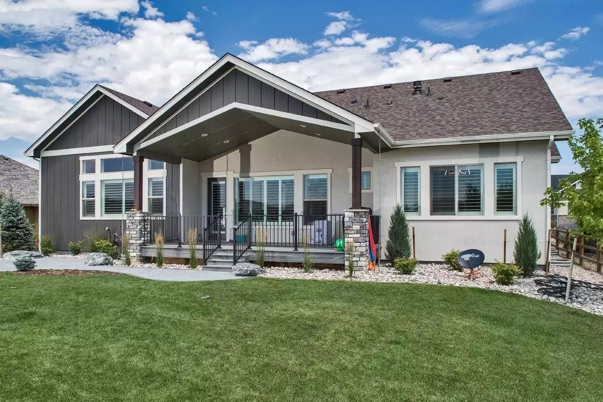 Craftsman Covered Porch with Stone Columns and Manicured Lawn
