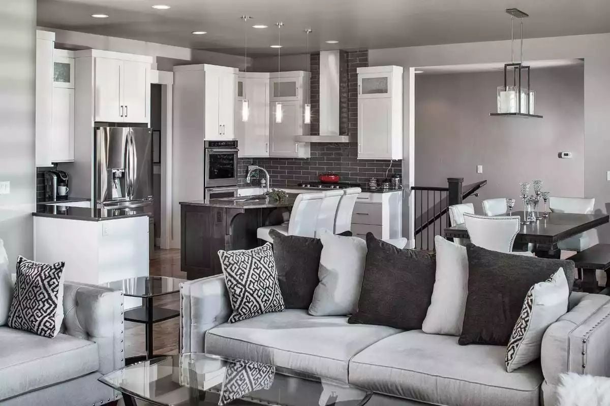 Open-Concept Living Flows Into a Kitchen Dressed in White Cabinets and Dark Brick