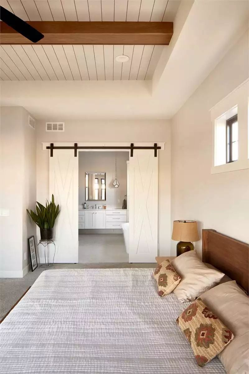 Barn Doors on Black Hardware Open Into a Farmhouse Ensuite
