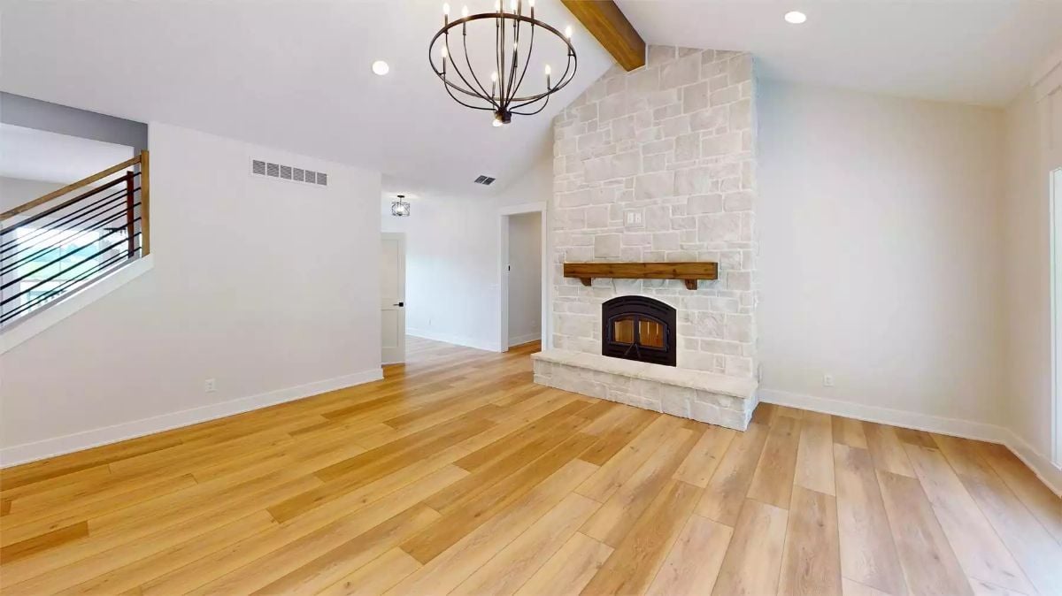 Floor-to-Ceiling Stone Fireplace Anchors This Light-Filled Living Room