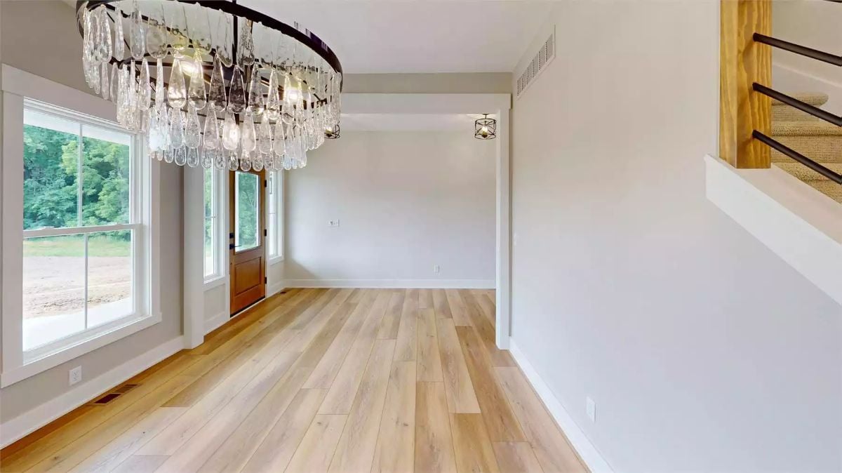 Crystal Chandelier and Hardwood Floors Set the Tone in This Farmhouse Foyer