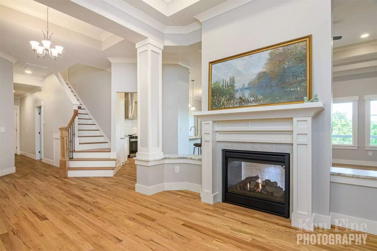 Coffered Ceiling and Column Framing Define an Open Living Space with Active Fireplace