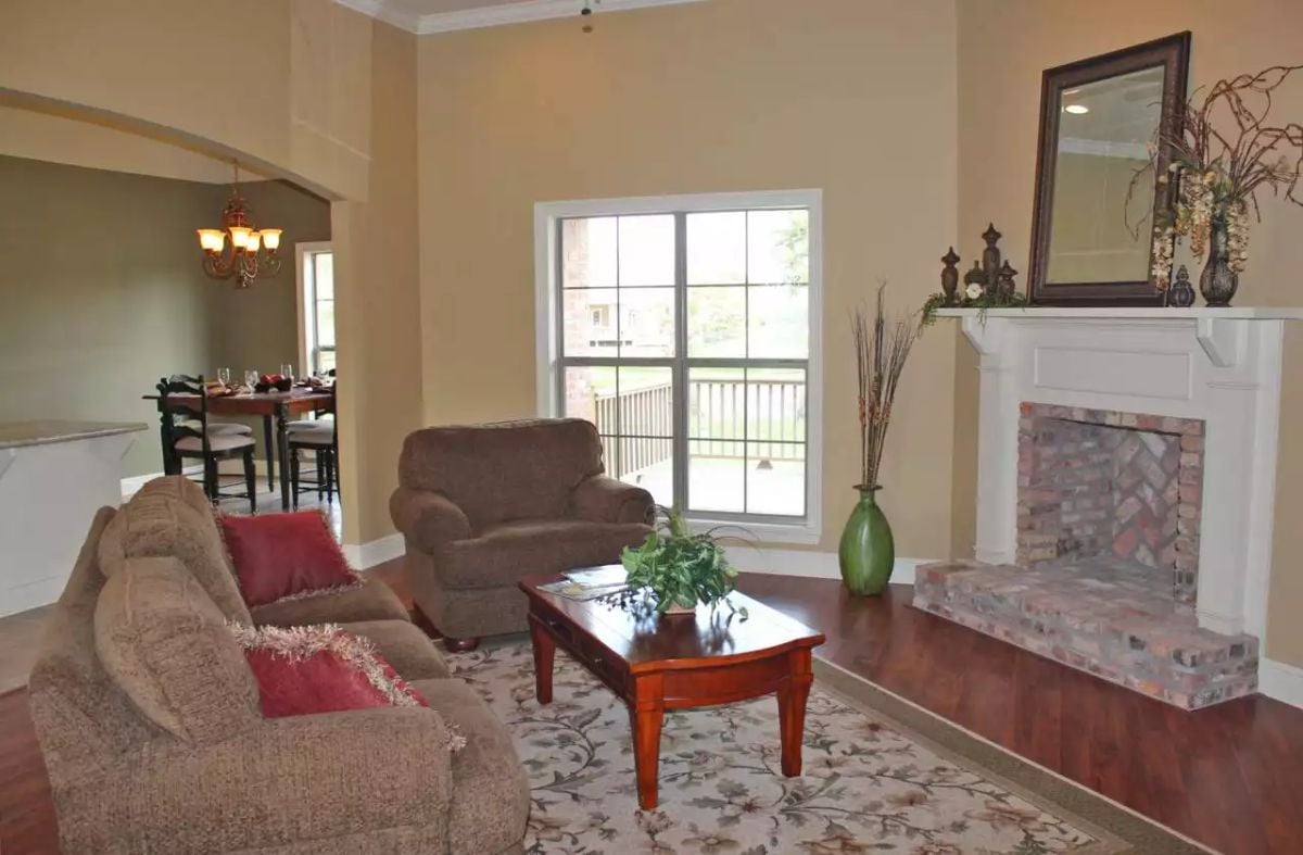 Warm Wood Floors and a Brick Fireplace Anchor This Open Living Space