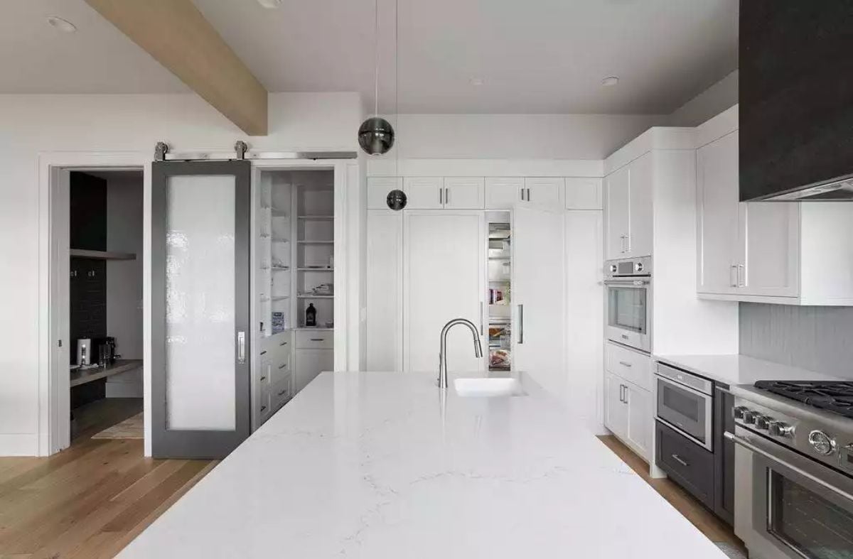 Modern Kitchen with White Marble Island and Sliding Pantry Door