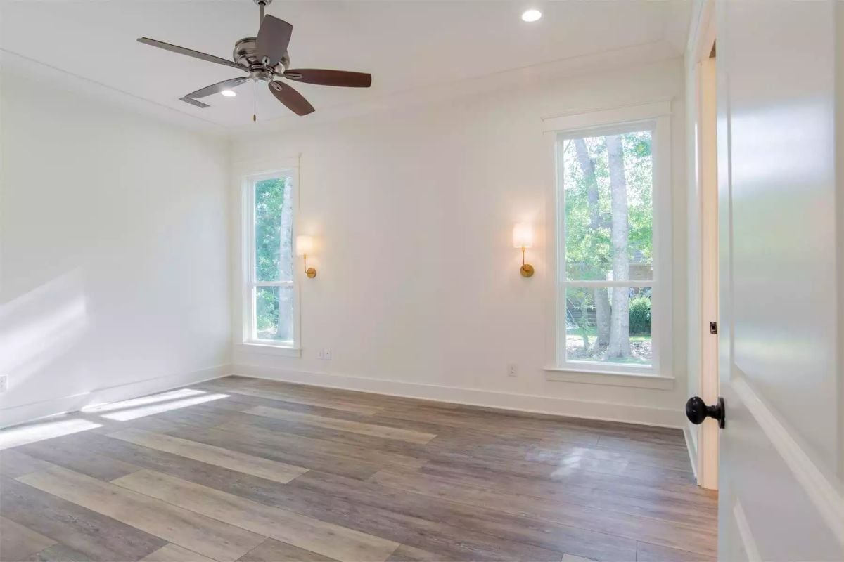 Gold Sconces Flank Two Windows in an Empty Room Ready for Furniture