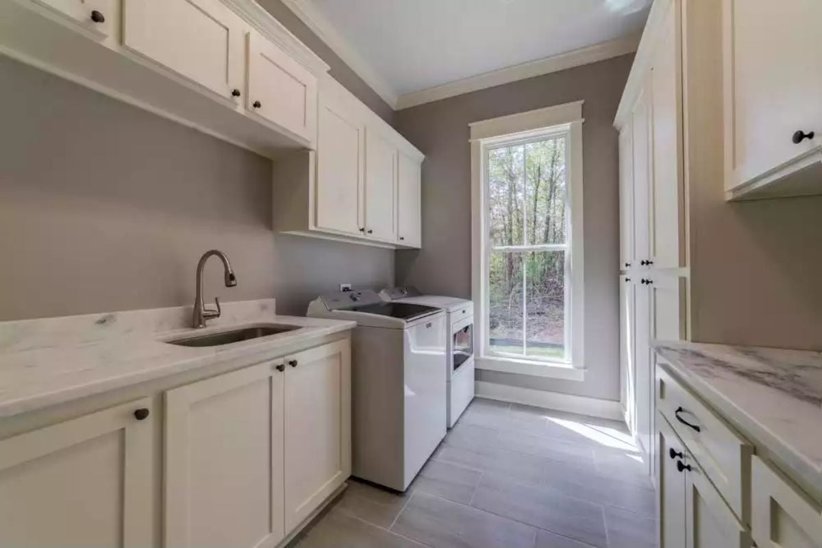 Marble Countertops and Dark Hardware Give This Laundry Room Real Utility