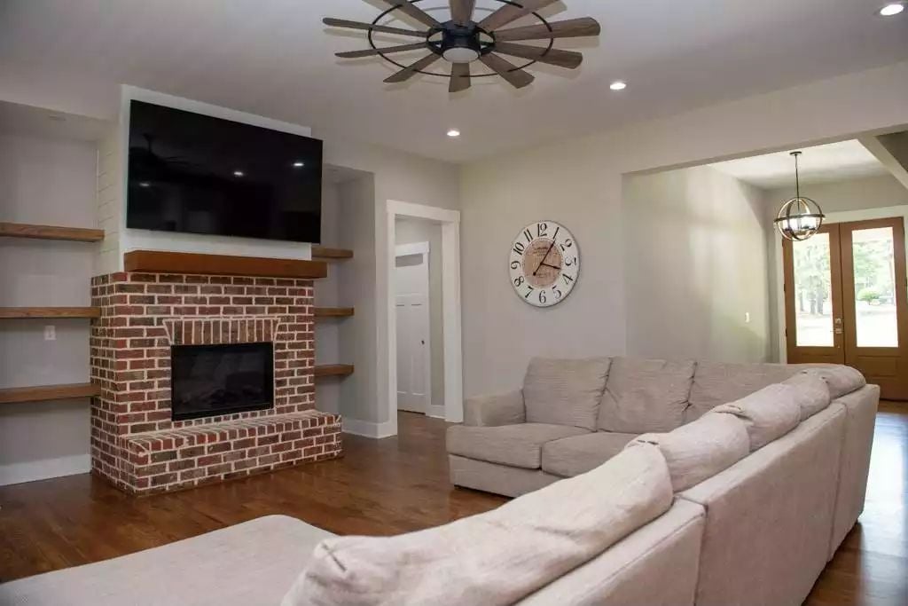 Brick Fireplace and Floating Shelves Anchor This Farmhouse Living Room