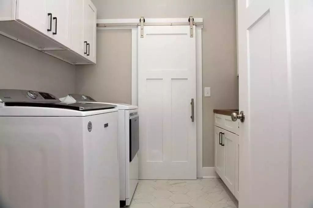 Sliding Barn Door and Hex Tile Floor Give This Laundry Room Farmhouse Character
