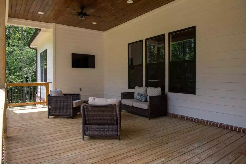 Covered Patio with Wicker Seating and Wall-Mounted TV for Outdoor Living