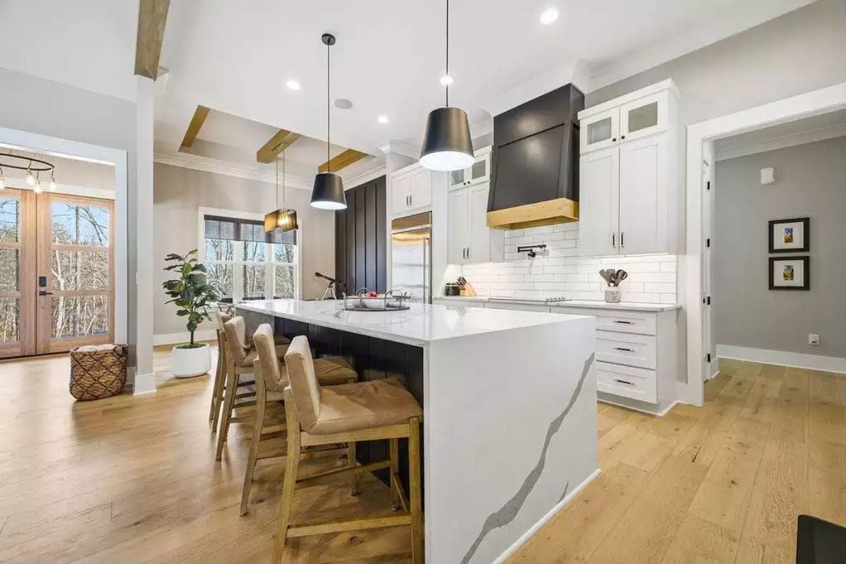Waterfall Quartz Island Anchors an Open Kitchen with Black Hood Accents