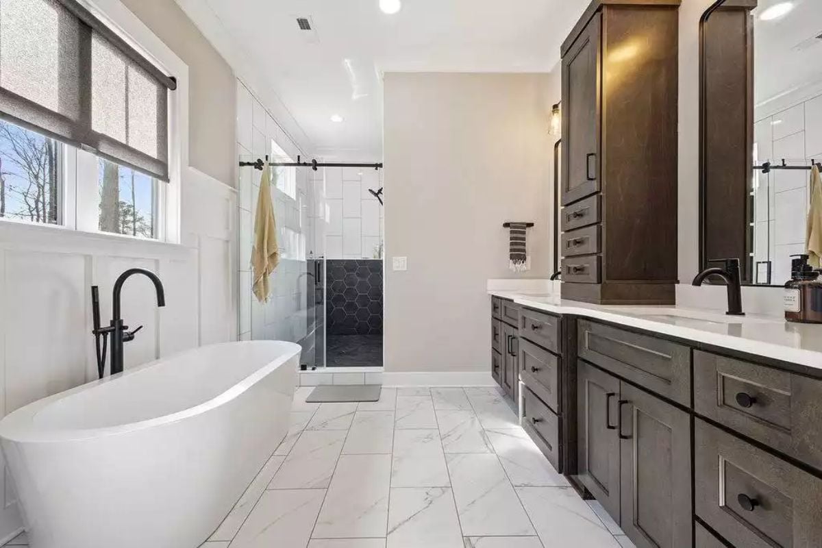 Freestanding Soaker Tub Faces a Walk-In Shower Wrapped in Hex Tile