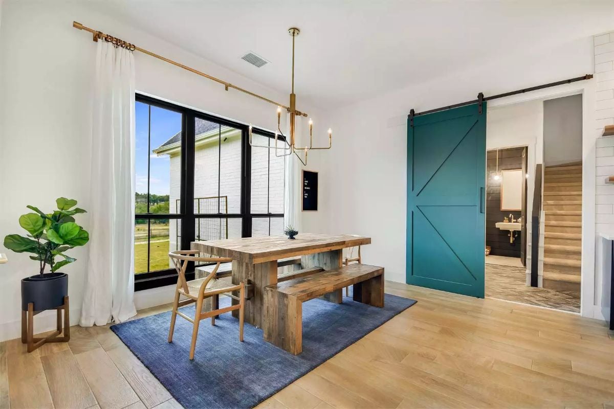 Rustic Dining Area with Reclaimed Wood Table and Teal Barn Door