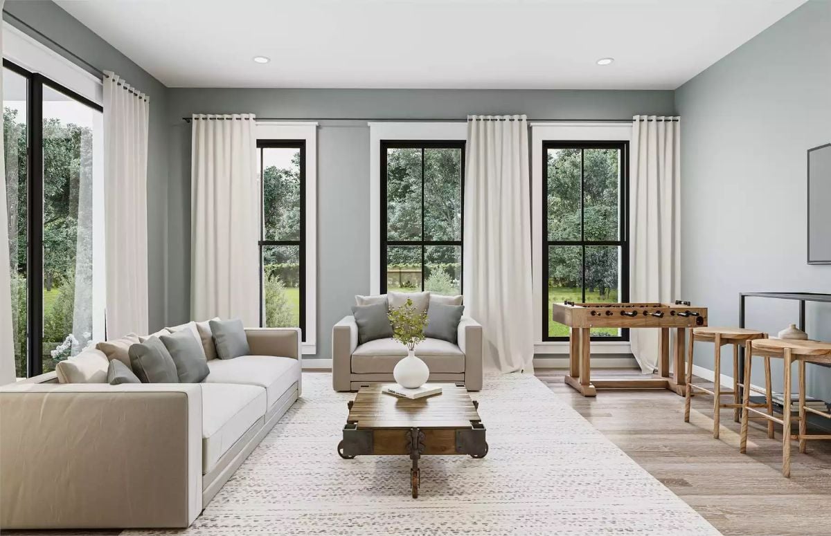 Sage-Walled Living Space with Foosball Table and Floor-Length Curtains