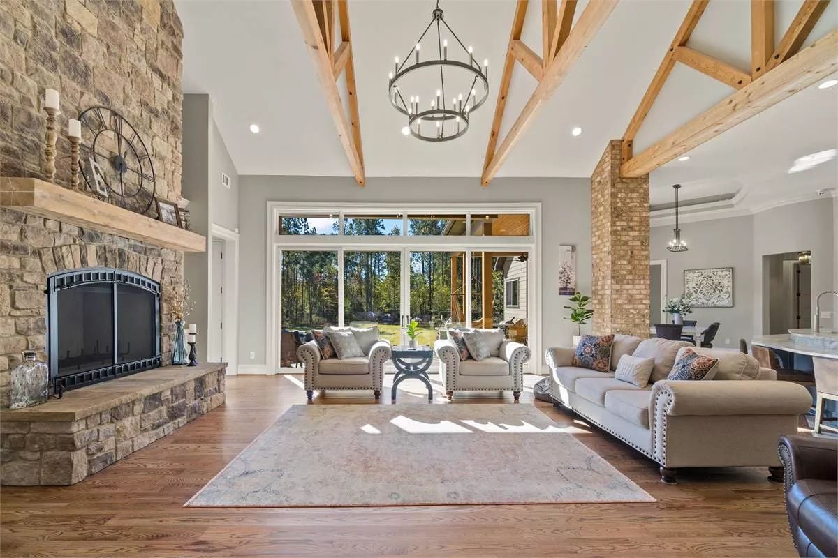 Soaring Stone Fireplace and Exposed Timber Beams Anchor This Great Room