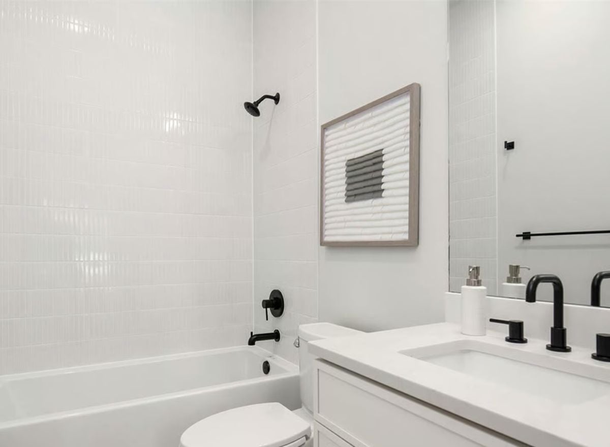 Matte Black Fixtures Pull Together Every Surface in This All-White Bathroom