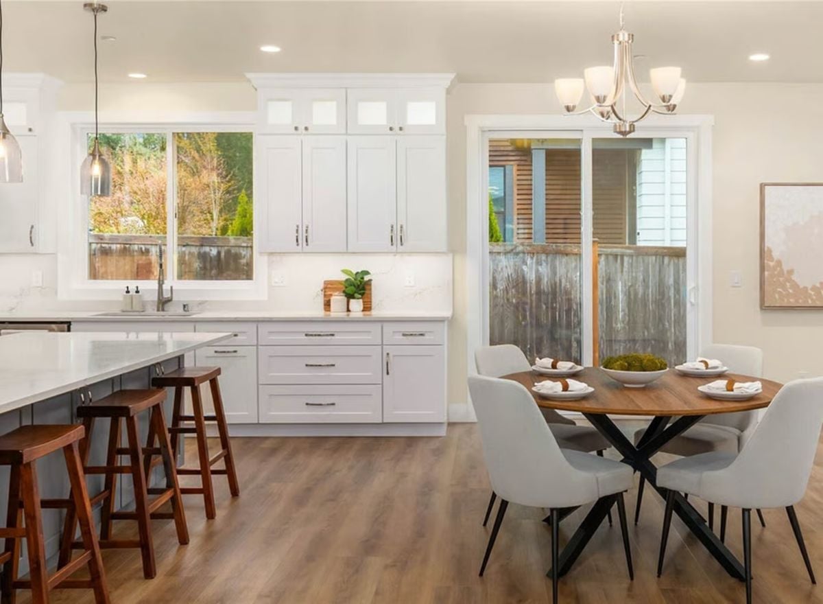 White Shaker Cabinets and Round Dining Table Bring Warmth to an Open Kitchen