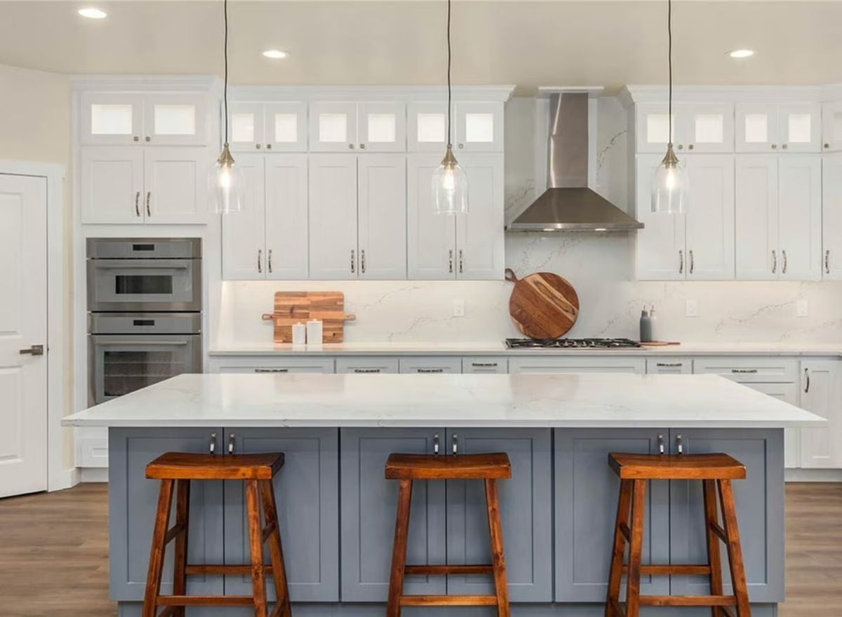Blue-Gray Island and Wood Stools Ground a White Craftsman Kitchen