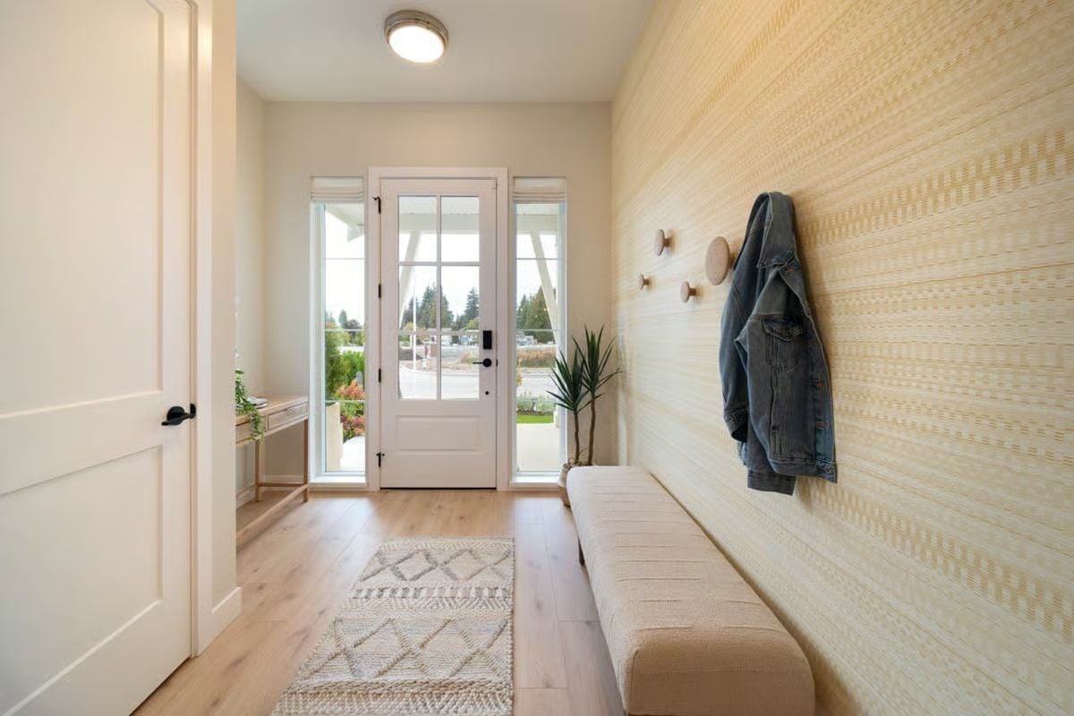 Wallpapered Mudroom Entry with Built-In Bench and Wooden Coat Hooks