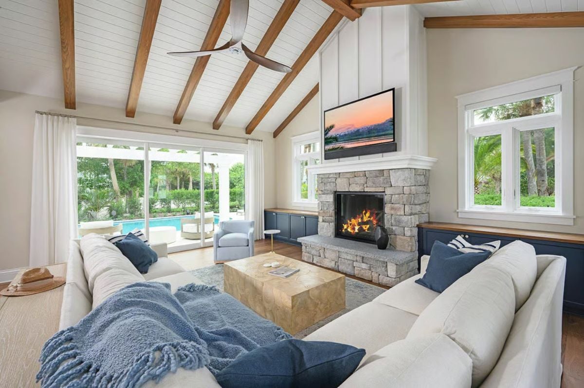 Vaulted Ceilings and a Stone Fireplace Define This Coastal Living Room