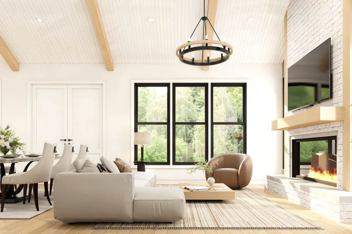Warm Wood Beams and a Leather Chair Ground This Barndominium Living Room