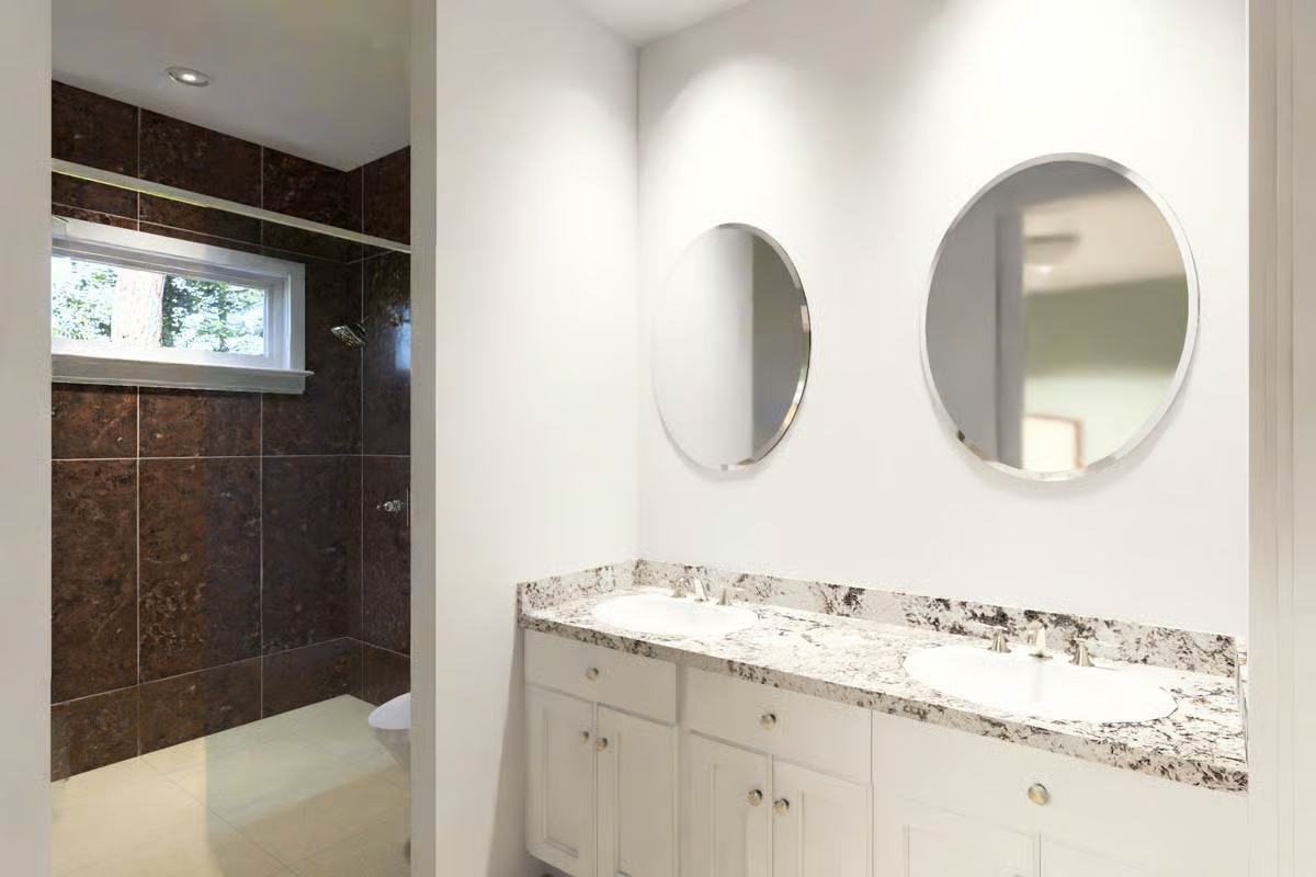 Round Mirrors and a Granite Double Vanity Define This Master Bath