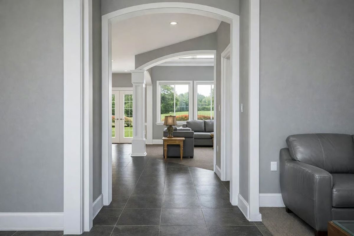 Arched Hallway with Dark Tile and Open Views Through to the Living Room