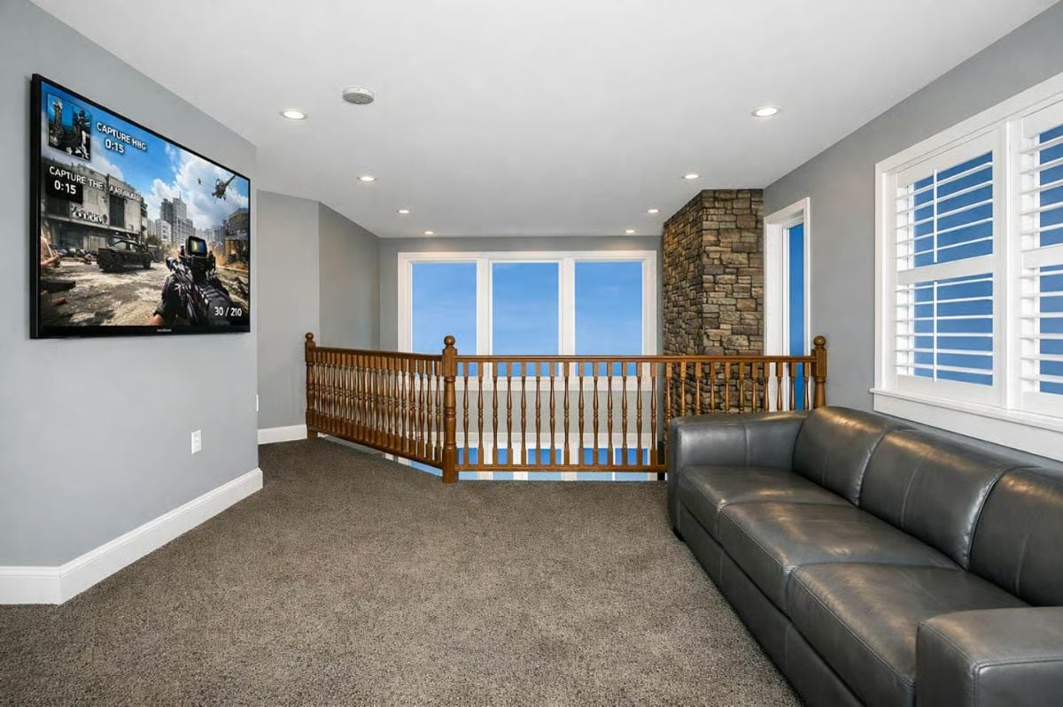 Loft Gaming Nook with Leather Seating and Wall-Mounted Action