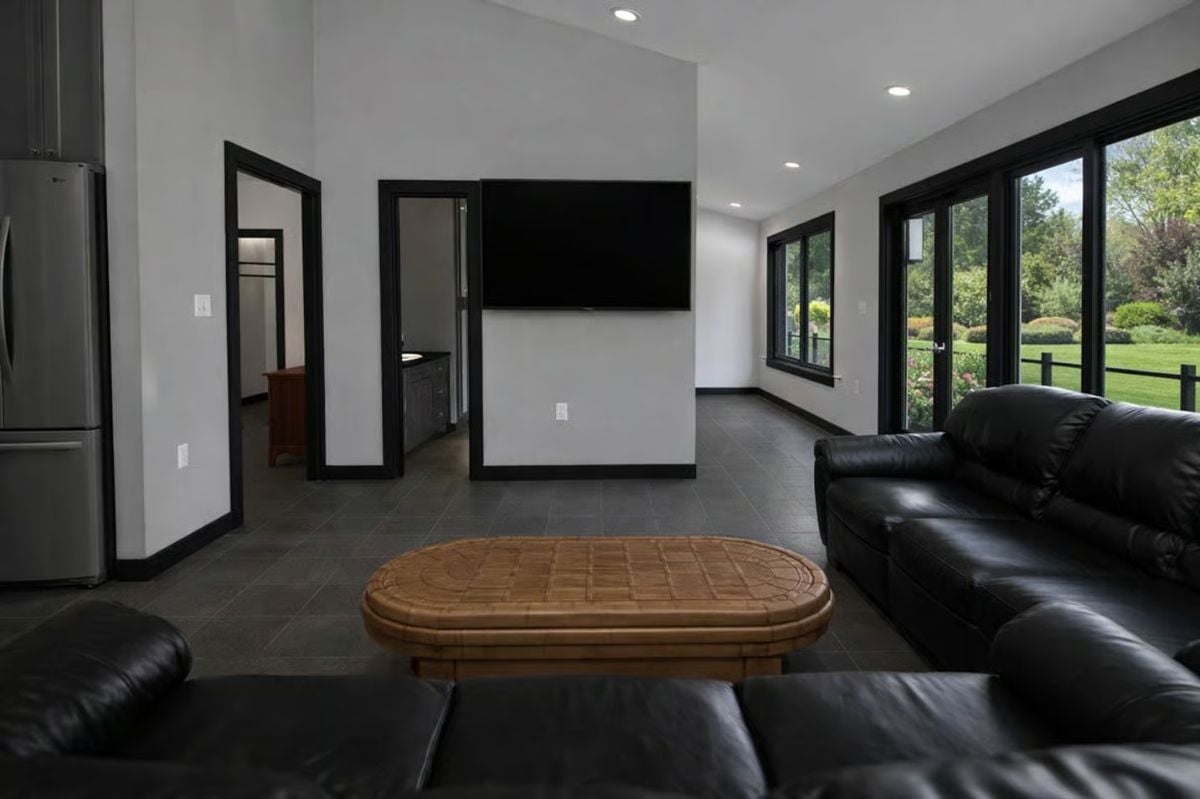 Black Leather Sofas and Recessed Lighting Define a Open-Concept Living Space