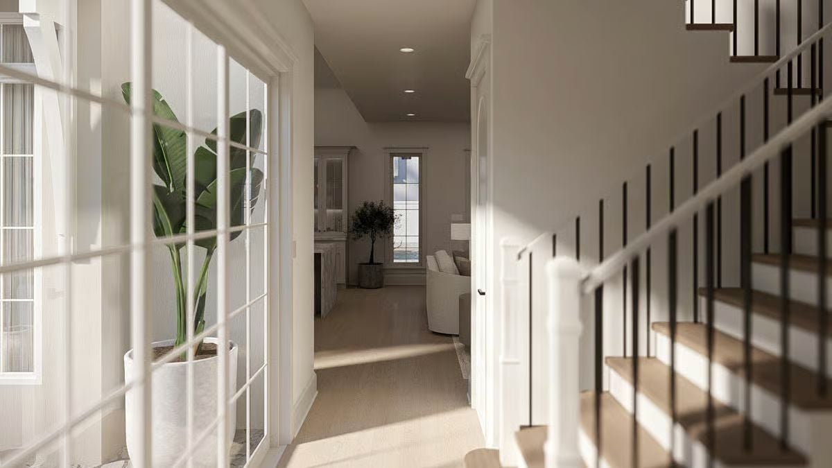 Sunlit Hallway Connects French Doors, Staircase, and Open Living Beyond