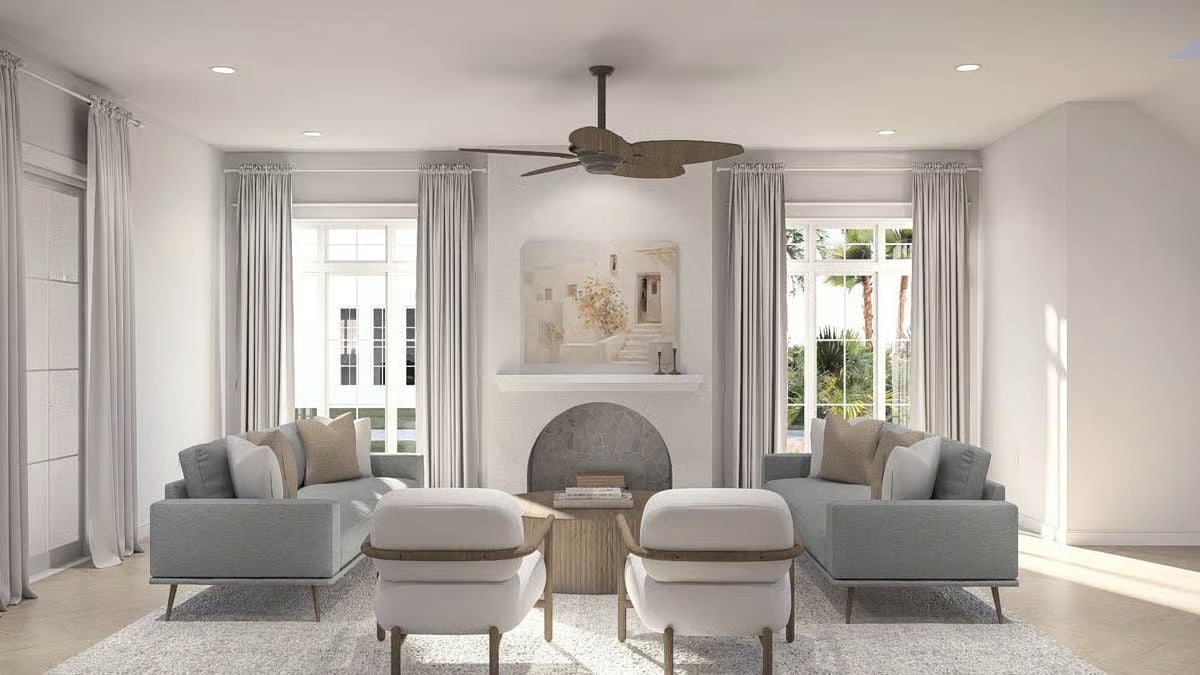 Paired Sofas and Ottoman Chairs Pull Focus Toward an Arched Fireplace