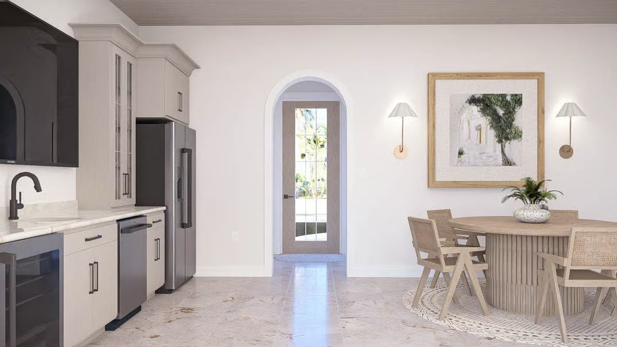 Arched Entry Door Frames Outdoor Light Behind a Round Pedestal Dining Table