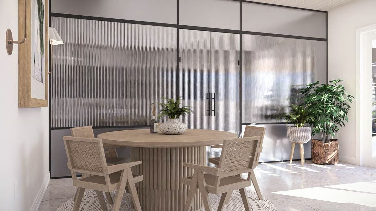 Reeded Table Base and Rattan Chairs Meet Fluted Glass Panels in a Dining Nook