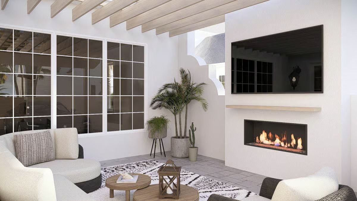 Exposed Ceiling Beams and a Linear Fireplace Anchor a White Stucco Sitting Room