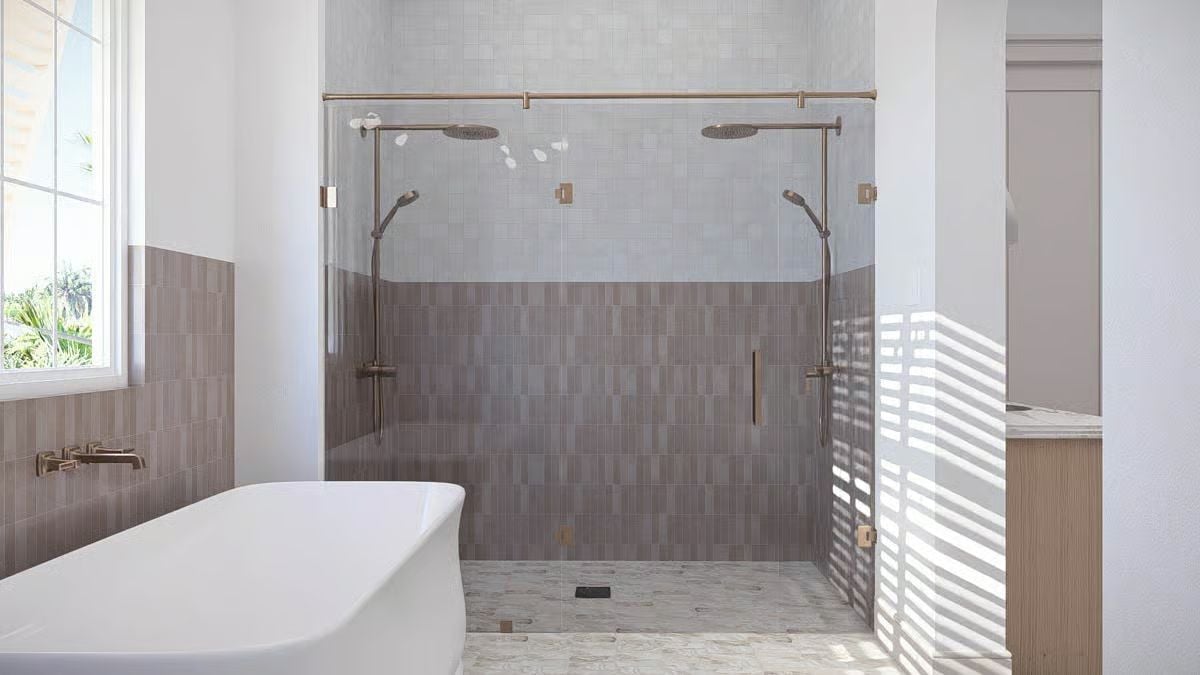 Dual Rain Heads and Brushed Bronze Hardware Fill a Glass-Enclosed Shower