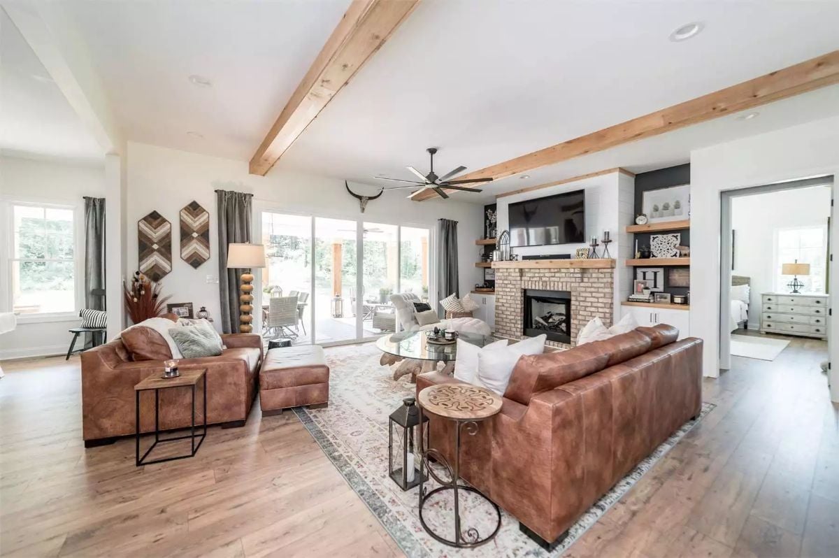 Exposed Ceiling Beams and Leather Sofas Define a Warm Craftsman Living Room