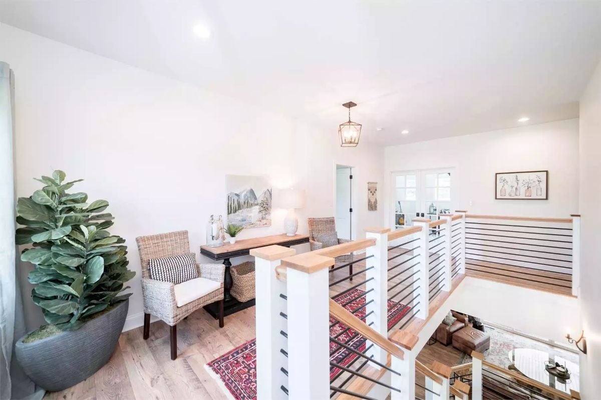 Loft Landing with Rattan Chairs and Open Railing Overlooks the Floor Below
