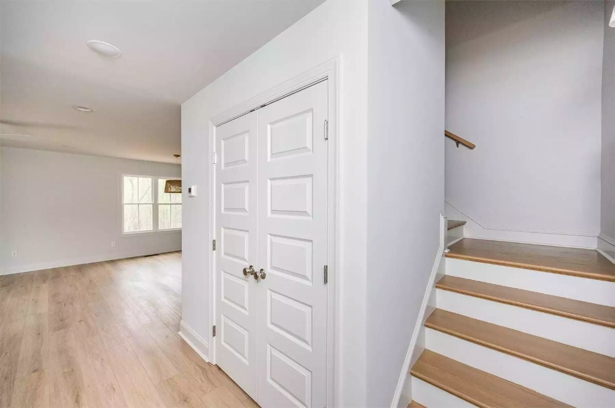 Double Closet Doors and Staircase Define a Hardworking Entryway