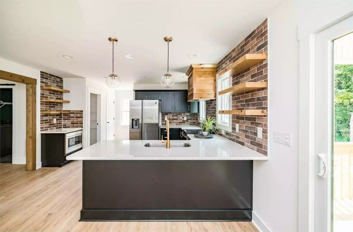Brick Accent Walls and Floating Wood Shelves Ground a Modern Craftsman Kitchen