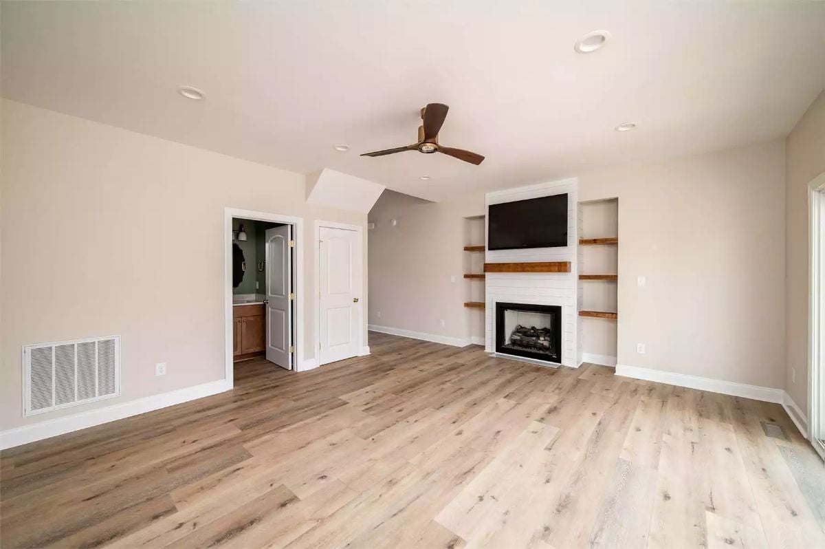 Warm Wood Floors and Built-In Shelves Anchor This Open Living Space